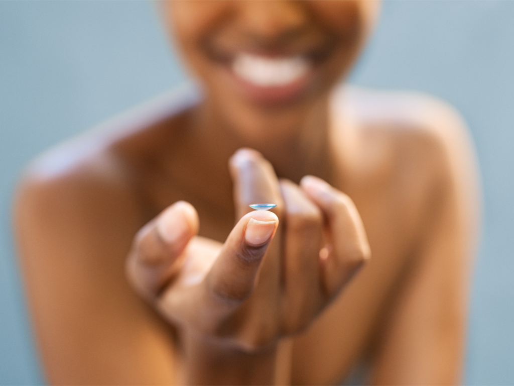 Ein Bild einer Frau, die eine Kontaktlinse auf dem Finger hält.