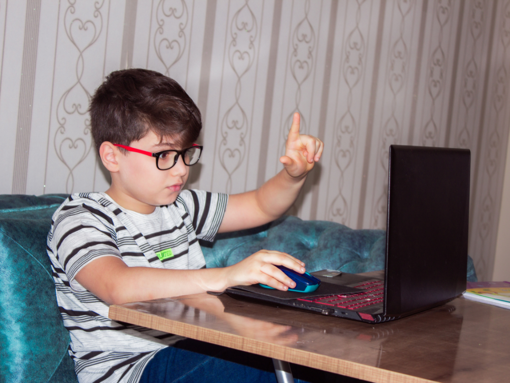Junge mit Brille am Laptop