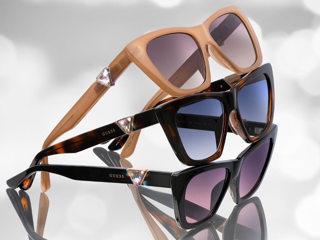 Drei Sonnenbrillen-Modelle aus der Marcolin und Guess Eyewear-Kollektion mit seitlichem Kristallstein, der das klassische Guess-Logo nachbildet.