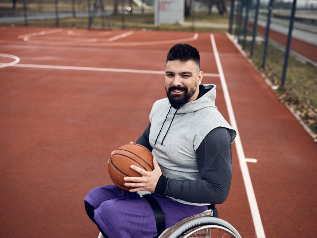Behinderter Sportler mit Basketball auf einem Sportplatz
