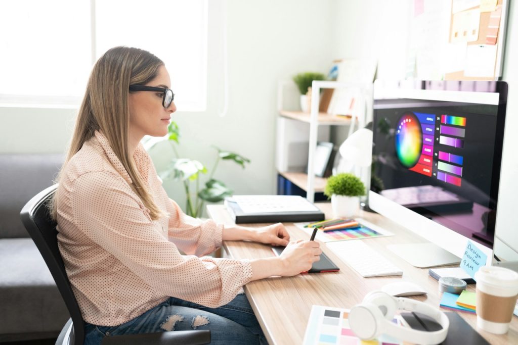 Frau im mittleren Alter trägt Brille und schaut auf PC-Bildschirm