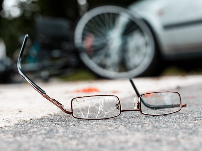 Kaputte Brille liegt vor Auto nach Unfall