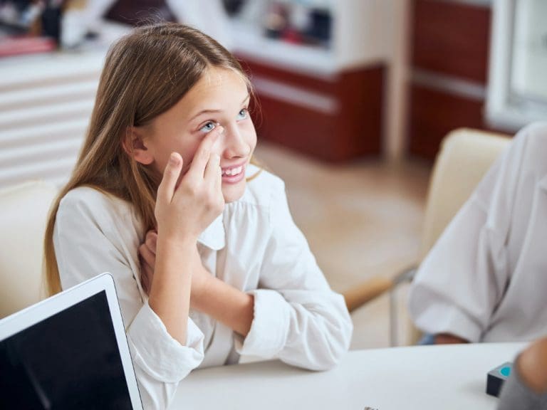 Mädchen setzt sich Kontaktlinse ein