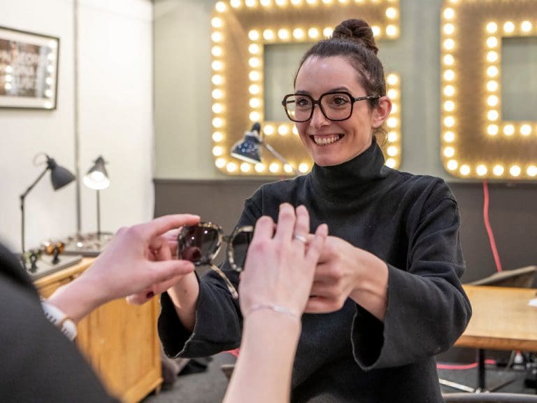 Frau zeigt Brille auf einer Augenoptik-Fachmesse