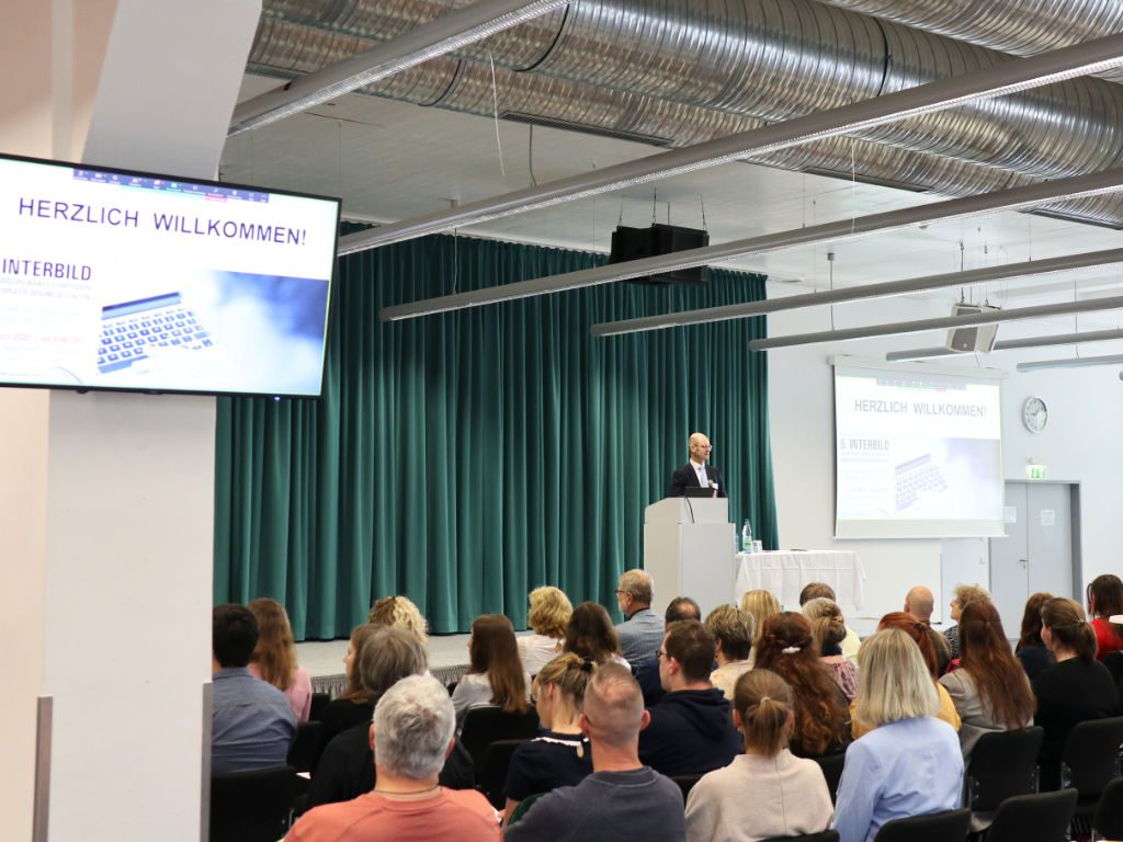 Prof. Dr. Stephan Degle auf der Bühne beim 5. Interbild-Symposium an der Ernst-Abbe-Hochschule Jena