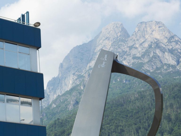 Ray-Ban-Brille gehalten vor dem Firmengebäude von EssilorLuxottica in Agordo, Italien