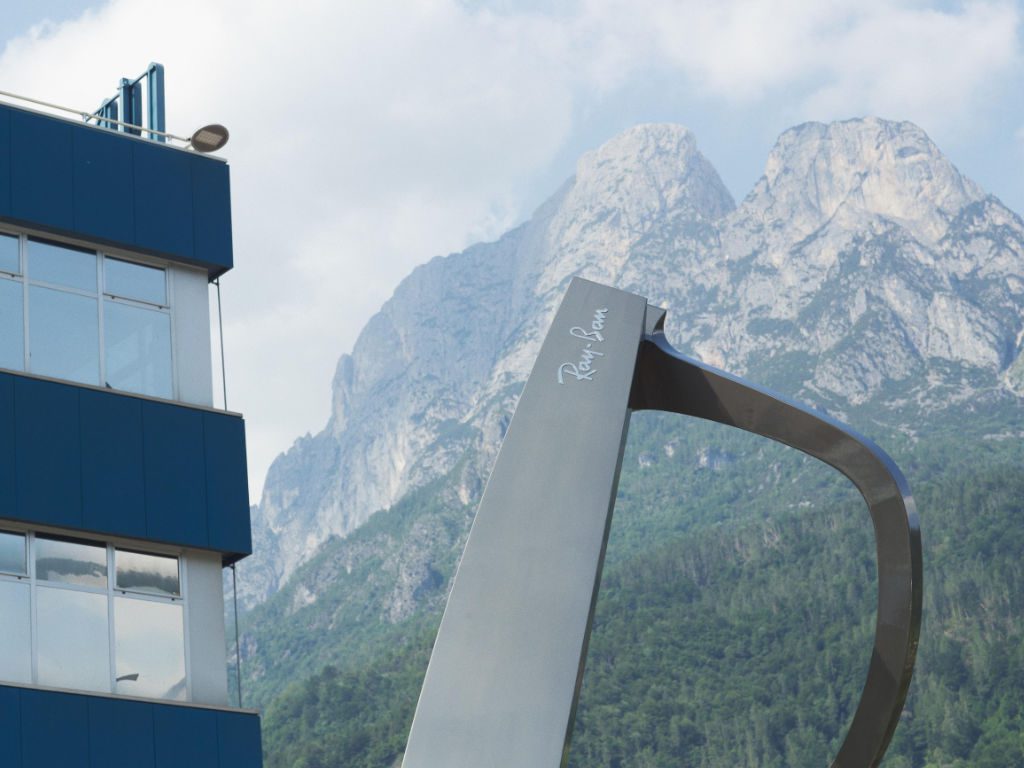 Ray-Ban-Brille gehalten vor dem Firmengebäude von EssilorLuxottica in Agordo, Italien