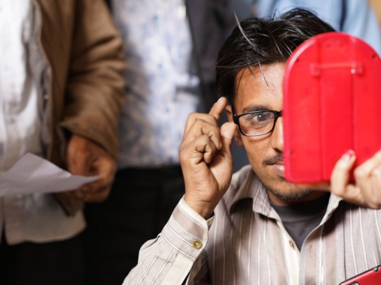 Mann in Indien testet Brille im Spiegel