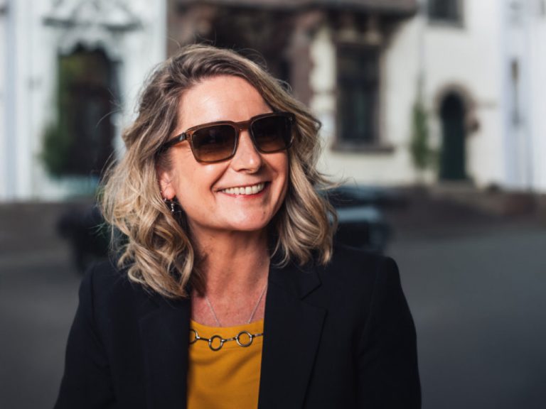 Frau mit Sonnenbrille lächelt