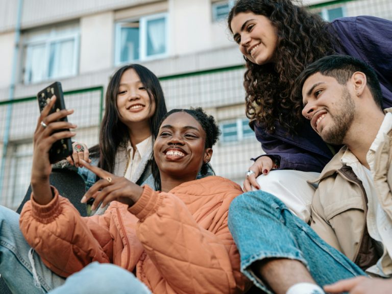 Junge Menschen aus der Gen Z gemeinsam vor dem Smartphone