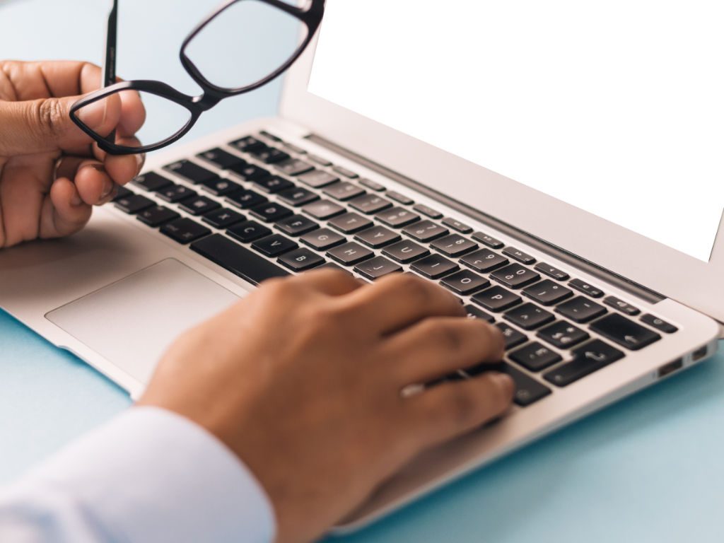 Hände tippen auf Laptop