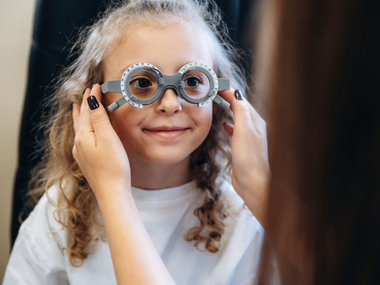 Mädchen trägt Messbrille bei Augenoptikerin