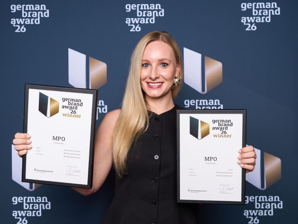 Nina Jokesch (Department Manager Marketing Lenses bei MPO Brillenglas) hält die zwei German Brand Awards 2026-Auszeichnungen in Händen