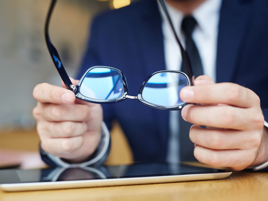 Nahaufnahme einer Brille mit Geschäftsmann bei der Arbeit