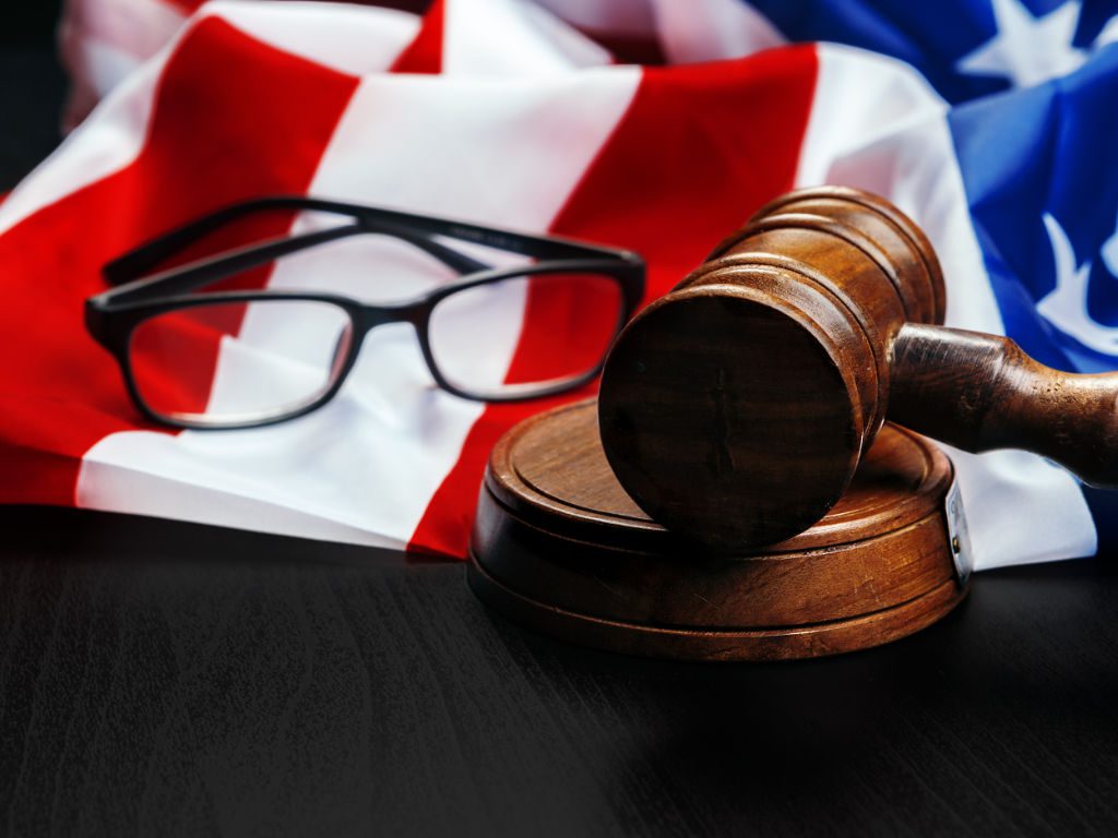 Gerichtshammer neben Brille und US-Flagge