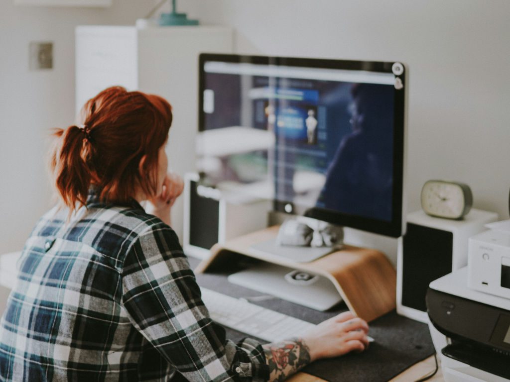Junge Frau schaut auf Computerbildschirm