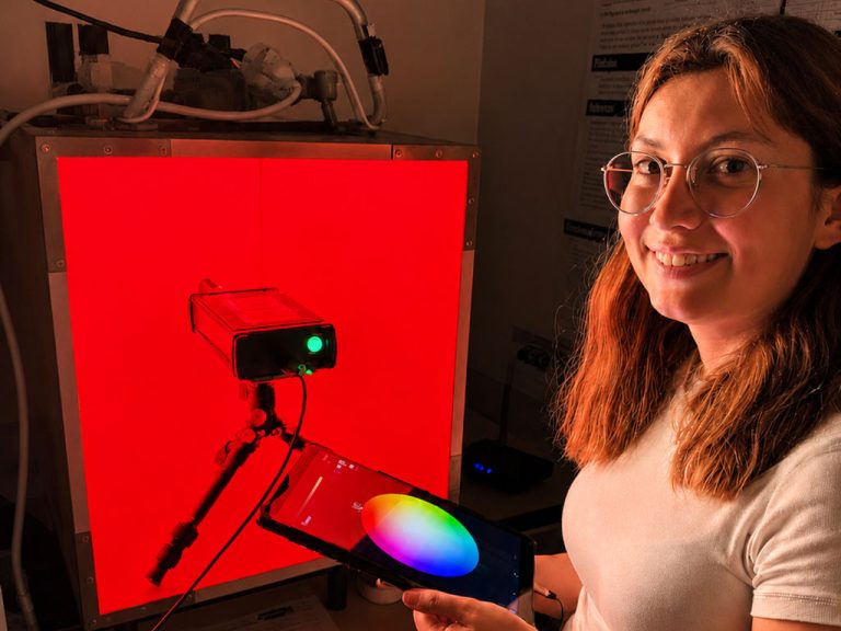 Augenoptik-Bachelorstudentin Vanessa Marie Brauer steht neben einer LED-Rotlichttherapie-Lichtbox
