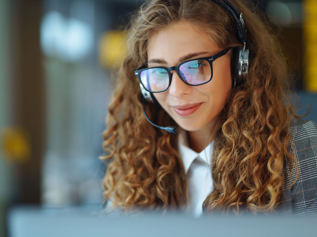Frau mit Headset am Arbeitsplatz im Büro